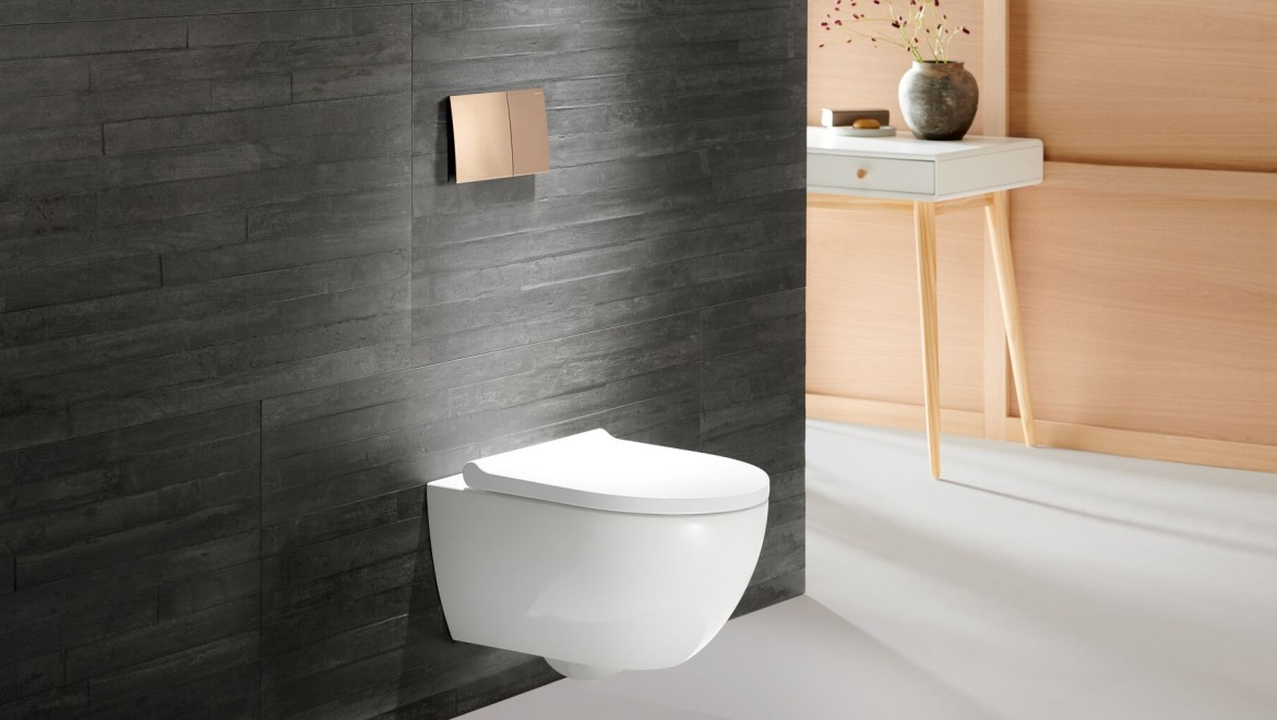 WC z serii łazienkowej Geberit Acanto z przyciskiem uruchamiającym w kolorze różowego złota