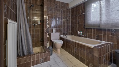 Łazienka z wąskim narożnikiem prysznicowym, wanną i WC stojącym na podłodze